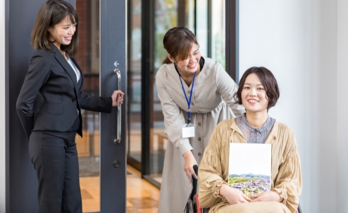 車椅子の女性が施設内に入場する写真